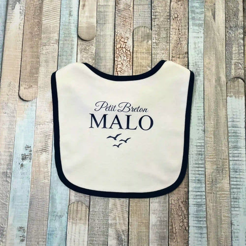 Bavoir blanc pour bébé garçon avec un liseré bleu m arine, personnalisé avec l'inscription Petit Breton Malo et un dessin de mouettes