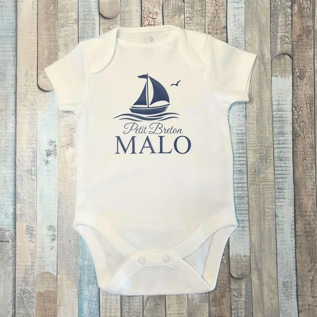 Body blanc à manches courtes pour bébé garçon, personnalisé avec le prénom Malo, l'inscription Petit Breton, un bateau à voile, le tout en bleu marine.  DIsponible en manches longues