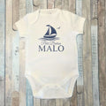 Body blanc à manches courtes pour bébé garçon, personnalisé avec le prénom Malo, l'inscription Petit Breton, un bateau à voile, le tout en bleu marine.  DIsponible en manches longues