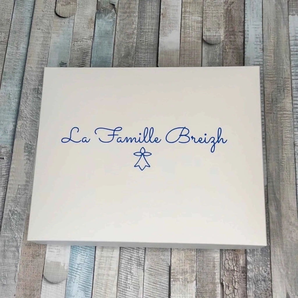 Coffret cadeau rectangulaire blanc imprimé avec l'inscription « La Famille Breizh » et le symbole de l'hermine bretonne en bleu.