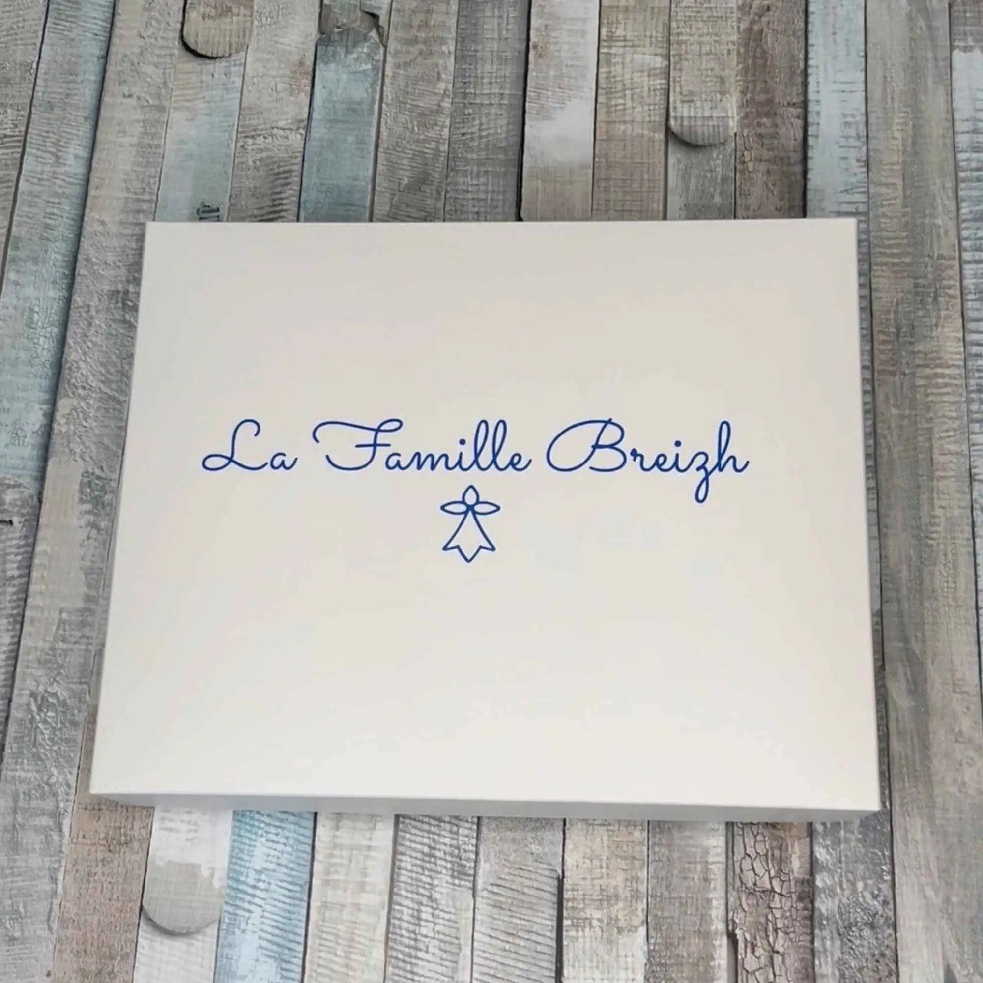 Coffret cadeau rectangulaire blanc imprimé avec l'inscription « La Famille Breizh » et le symbole de l'hermine bretonne en bleu.