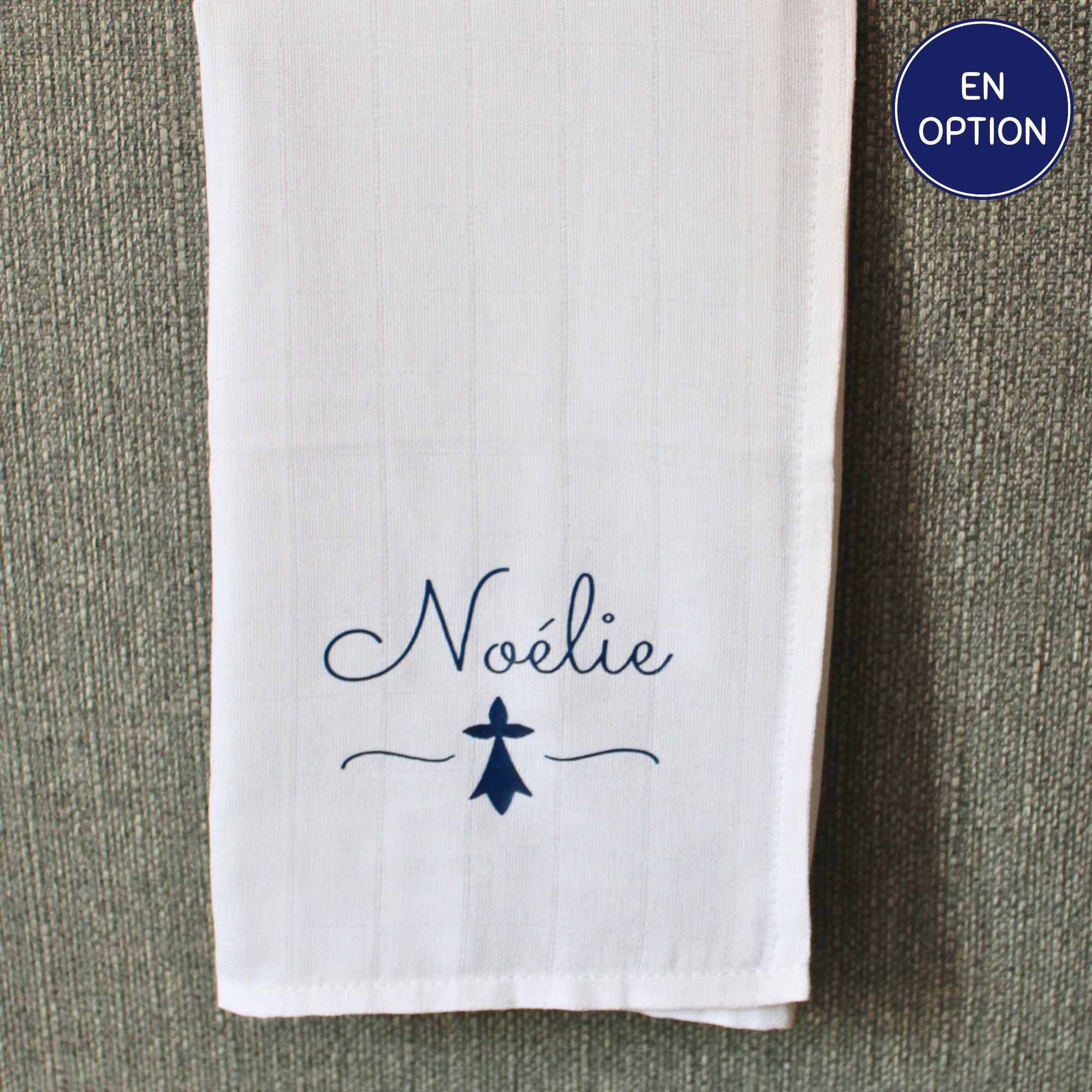 Lange en coton blanc pour bébé personnalisé avec le prénom Noélie écrit en bleu marine au-dessus d'un symbole d'hermine bretonne.